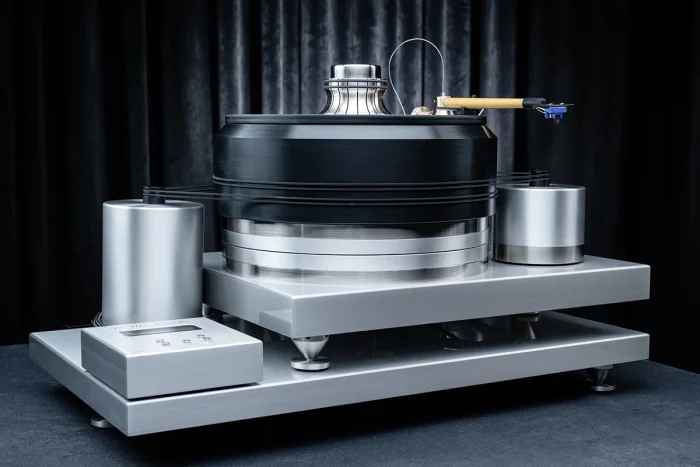 J.Sikora Turntables standard line Hi End turntable from J.Sikora, the standard line is a hi end turntable with very high manufacturing standards. The total weight of the turntable reaches 80 kg with only the platter reaching 18 kg. The platter is made of Delrin® and cast iron. The turntable uses materials such as aluminum, brass, copper, inox and bronze. The bearing is inverted with a ceramic ball. The turntable uses 2 DC motors and a rubber belt with an arm (+1 optional). It comes with a heavy-duty clamp and glass mat and external power supply and is available in black or silver.