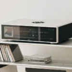 HiFi Rose RS151 Μηχανική ήχου "άλλου" επιπέδου Το RS151 βασίζεται στο αναγνωρισμένο RS150B με έναν πλήρως ανασχεδιασμένο πυρήνα ψηφιακής επεξεργασίας για ακόμη μεγαλύτερη καθαρότητα, λεπτομέρεια και μουσικότητα. Τώρα, διαθέτοντας τη μονάδα ROSE DPC™ και ένα αναβαθμισμένο ρολόι Femto, το RS151 μειώνει σημαντικά το jitter, βελτιώνει την ακρίβεια του σήματος και υποστηρίζει upsampling PCM-to DSD512 για μια ακόμη πιο ζωντανή παρουσίαση. Το συμπαγές αλουμινένιο πλαίσιο με ακρίβεια κατεργασίας ελαχιστοποιεί τους κραδασμούς, μεγιστοποιώντας παράλληλα τη θερμική απόδοση, εξασφαλίζοντας άψογη ηχητική απόδοση σε οποιαδήποτε εγκατάσταση.